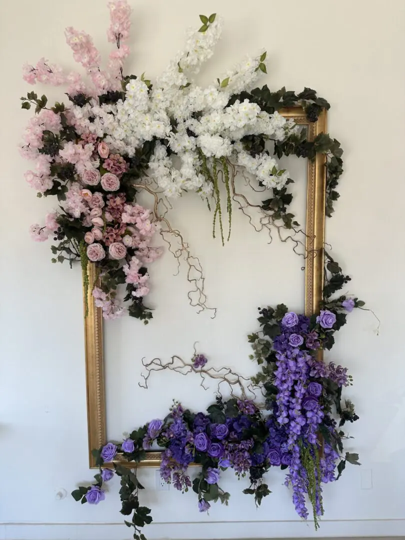 Floral arrangement in ornate gold picture frame.