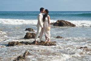 A wedded couple kissing on the beach