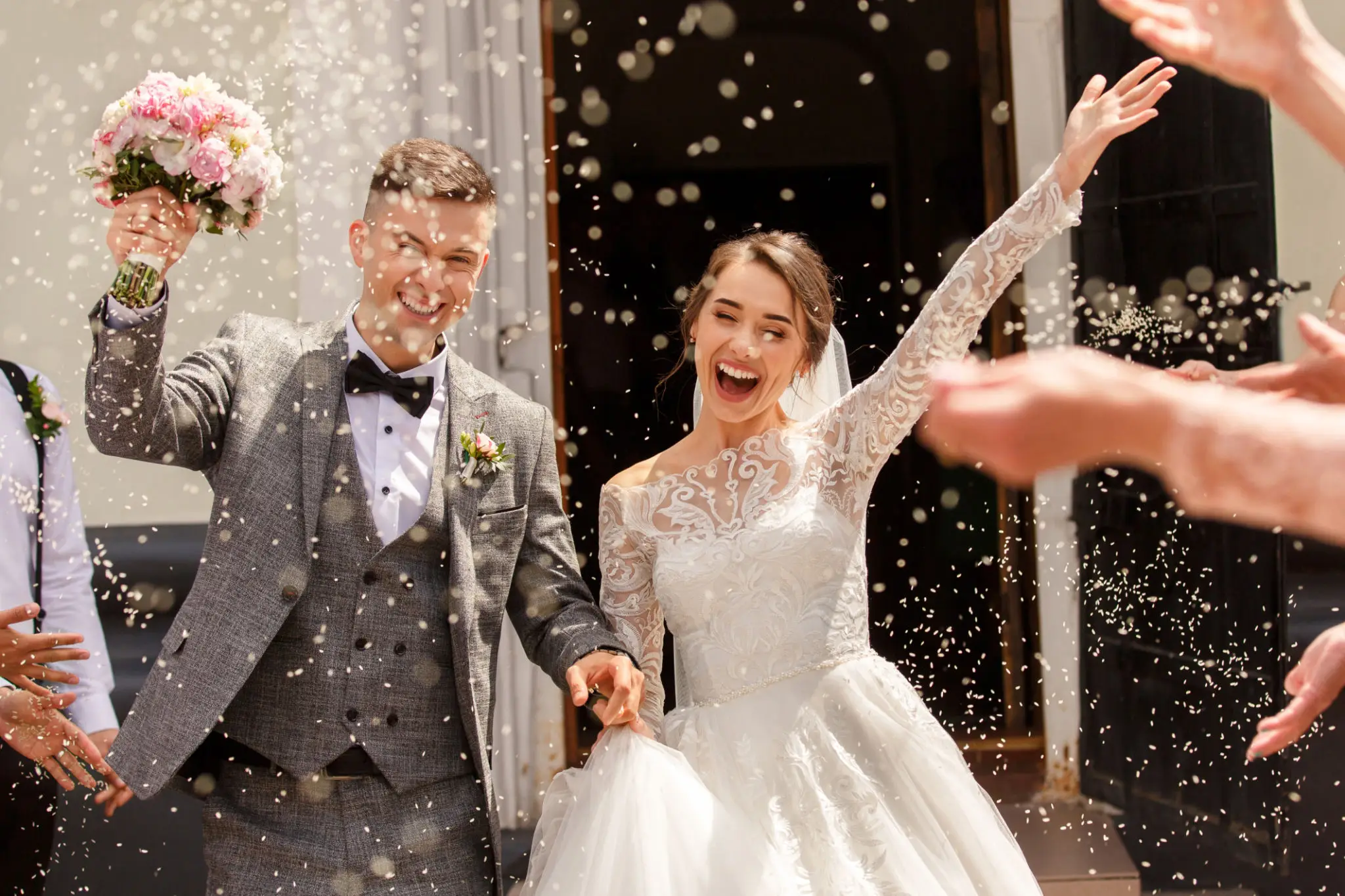 Joyful newlyweds celebrating with confetti after their wedding ceremony.